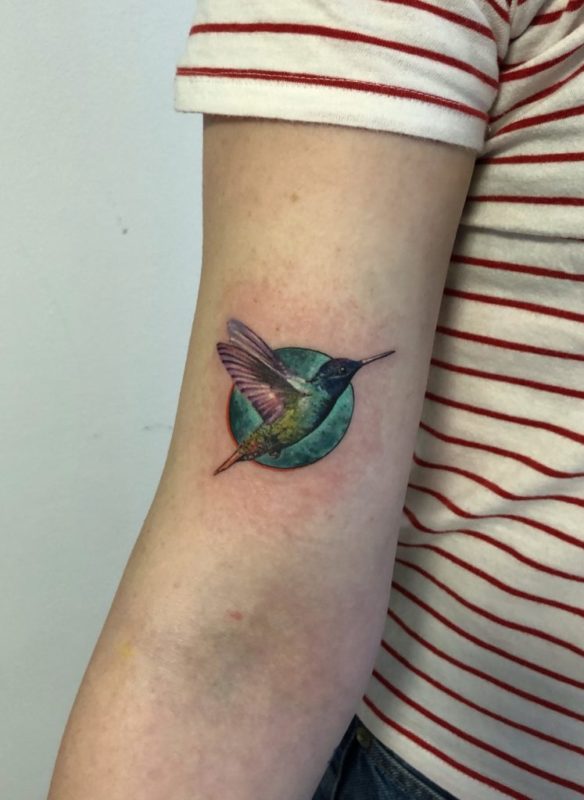 Fine line hummingbird tattoo on the wrist.